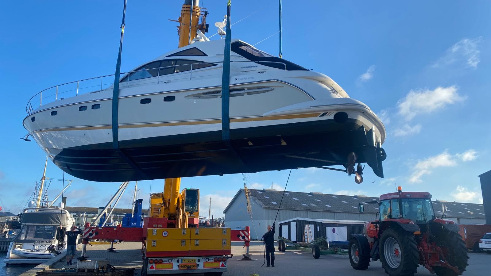 Kran løfter yacht ved optagning til bådhal i Hundested