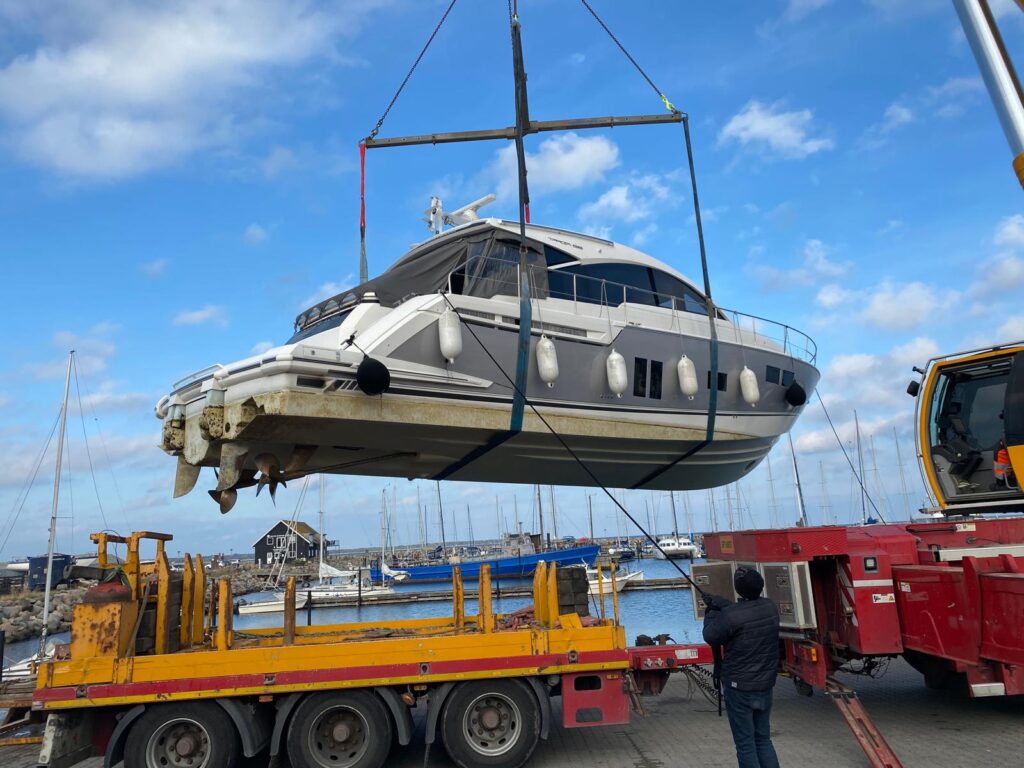 Yacht hejses op fra vandet med kran og læsses på lastbil ved optagning